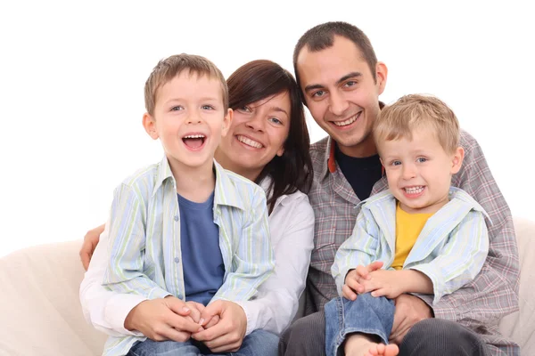 母亲父亲和两个儿子在沙发上 幸福家庭 图库照片