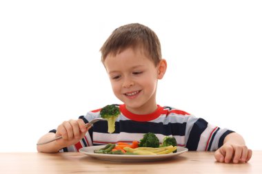 5-6 years old boy and plate of cooked vegetables isolated on white /focus on broccoli/ clipart