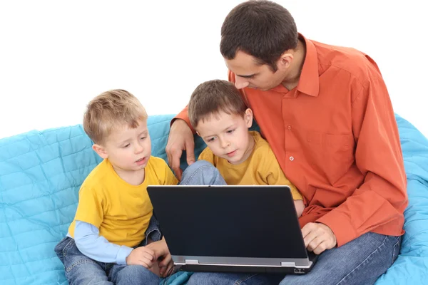父亲和两个儿子在沙发上玩电脑游戏 — 图库照片