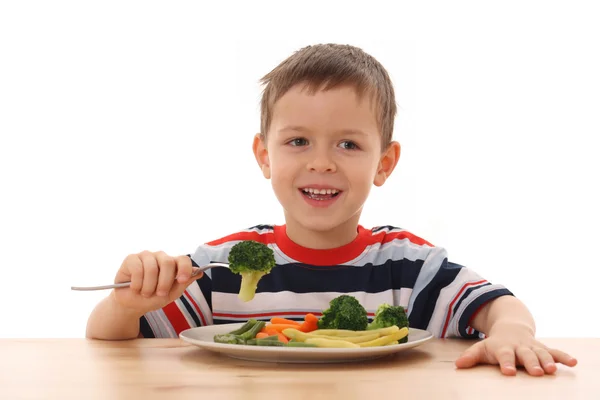 Мальчик и приготовленные овощи — стоковое фото