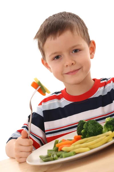 岁的男孩和煮熟的蔬菜上白色隔离板 — 图库照片