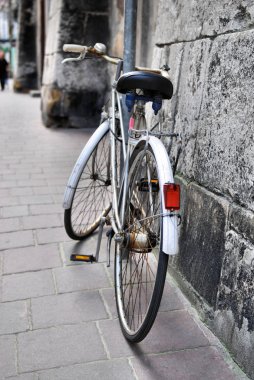 Old bicycle on city street clipart