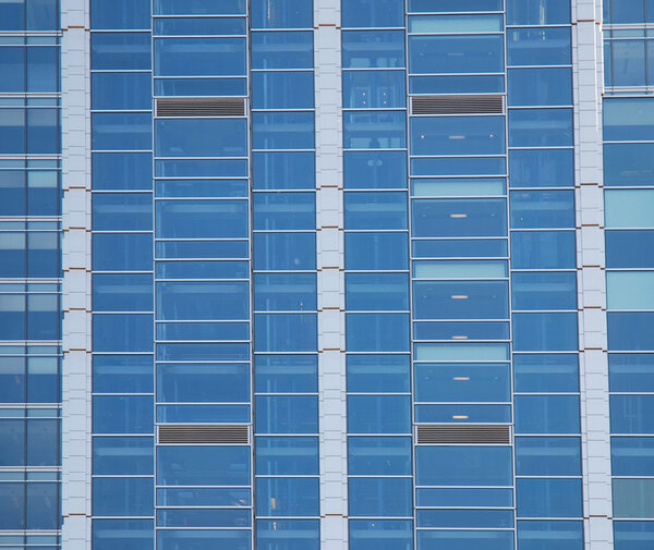 Wall of modern office building and sky reflection