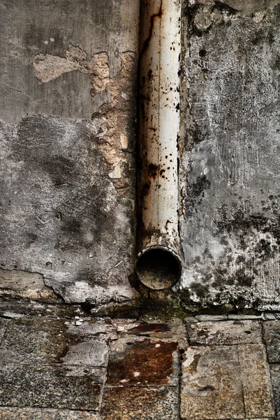 Іржава водопровідна труба на гранжевій стіні — стокове фото