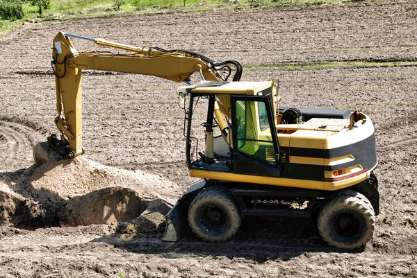Foto de uma escavadora em funcionamento no campo — Fotografia de Stock
