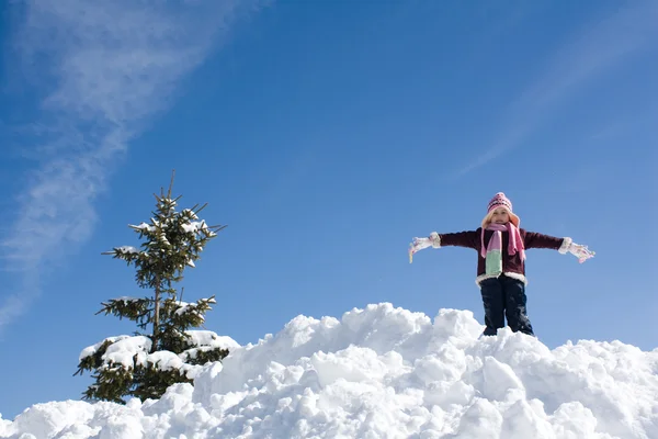 Klein meisje spelen in de sneeuw — Stockfoto