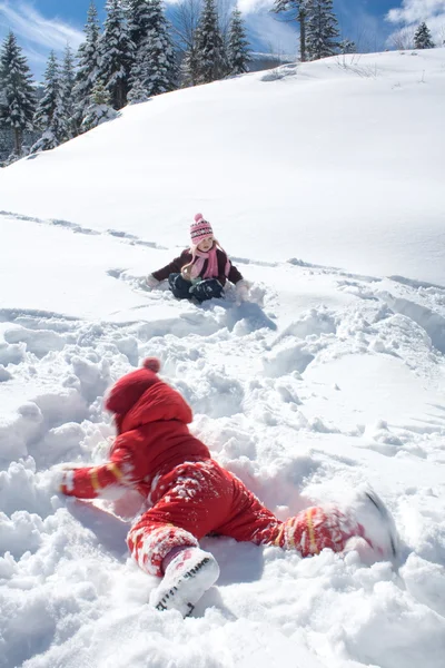 小さな女の子が雪の上で遊んで — ストック写真