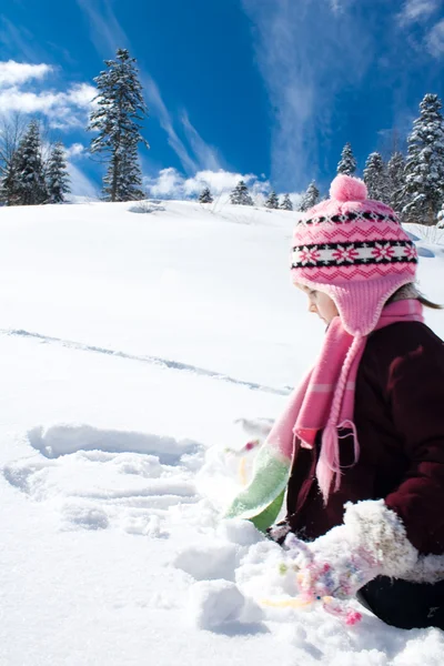 Klein meisje spelen in de sneeuw — Stockfoto