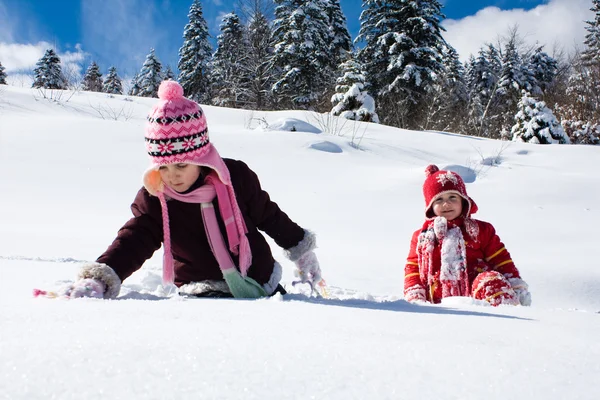 Маленькая девочка играет на снегу — стоковое фото