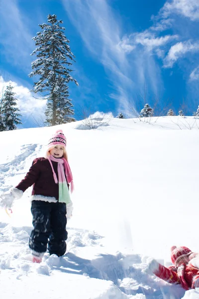 Kleines Mädchen spielt auf dem Schnee — Stockfoto