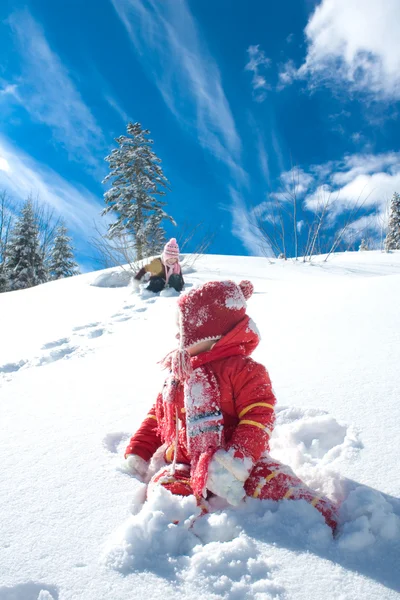 小さな女の子が雪の上で遊んで — ストック写真