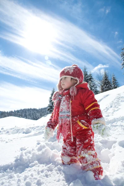 Kleines Mädchen spielt auf dem Schnee Stockfoto