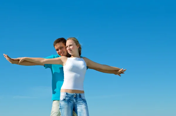 Молодая красивая пара обнимает голубое небо — стоковое фото