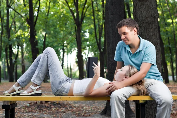 Молодая пара читает книгу в парке — стоковое фото