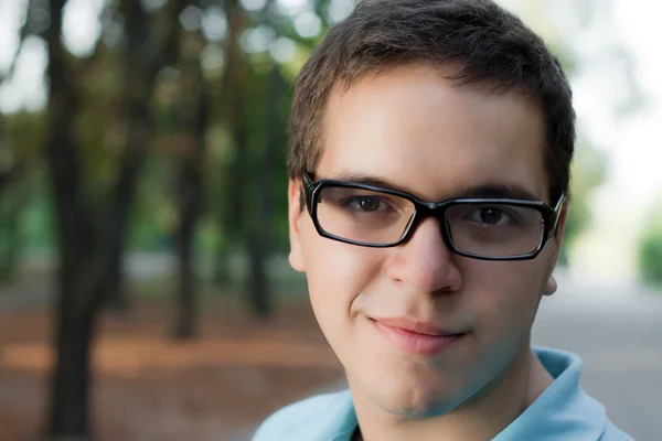 Retrato de hombre joven en gafas de pie al aire libre — Foto de Stock