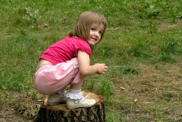 Kleines Mädchen auf dem Baumstumpf — Stockfoto