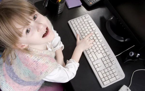 Маленькая девочка и компьютер — стоковое фото