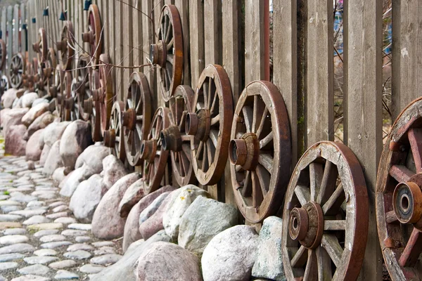 Rodas estão penduradas em uma cerca — Fotografia de Stock