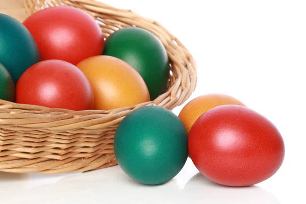 Colour Easter eggs in a wattled basket — Stock Photo, Image