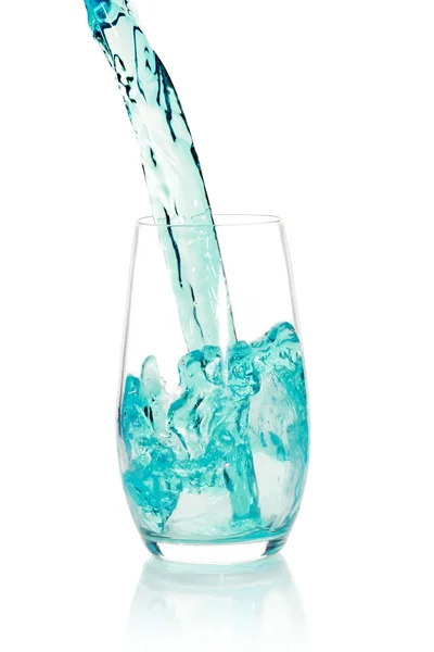 Glass with splashing blue drink — Stock Photo, Image
