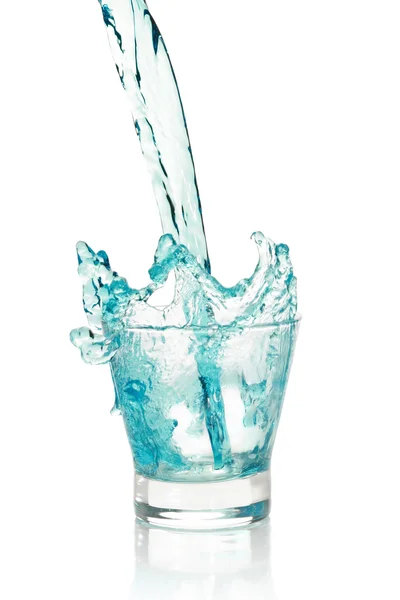 Glas mit spritzendem blauen Getränk — Stockfoto