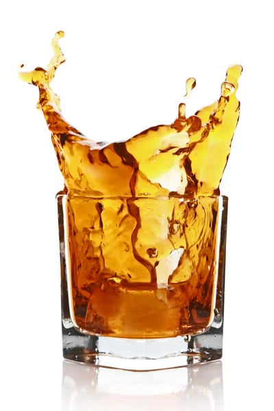 Glass with splashing whisky drink — Stock Photo, Image