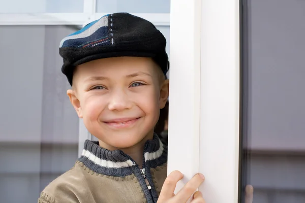 Sonriente niño en la ventana —  Fotos de Stock