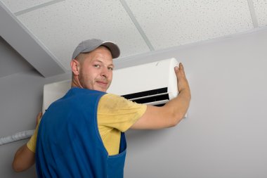 Installer sets a new air conditioner clipart