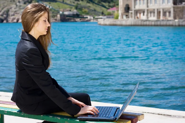 Kobieta z laptopa w pobliżu morza — Zdjęcie stockowe