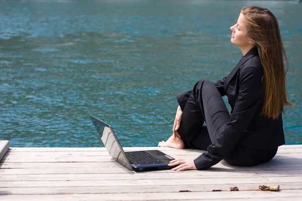 Vrouw met laptop en zee — Stockfoto