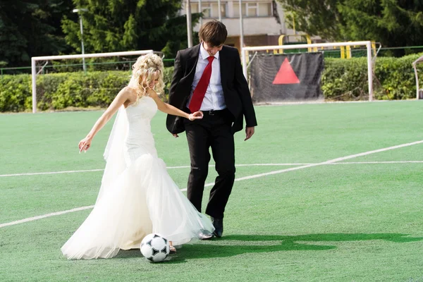 Wedding couple playing football — Stock Photo, Image