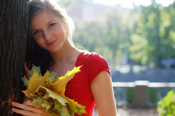 Женщина с желтыми листьями — стоковое фото