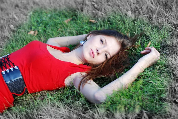 Ung kvinna och grönt gräs — Stockfoto