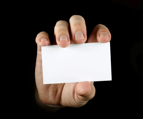 Hand met zwarte visitekaartje op zwarte b — Stockfoto