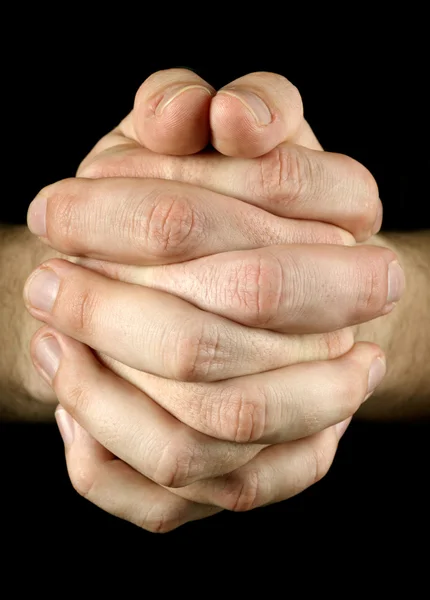 Orando con las manos sobre fondo negro — Foto de Stock