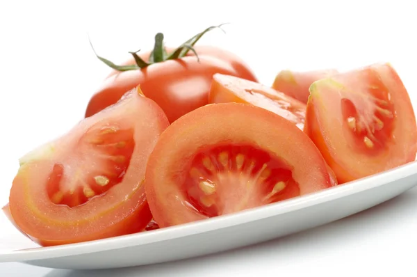 Rodajas de tomate y tomate en plato blanco —  Fotos de Stock