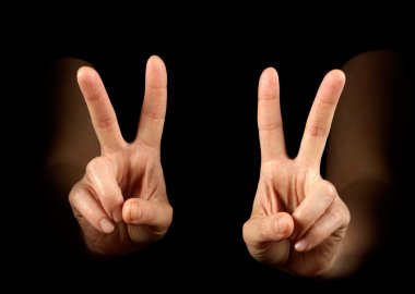 Woman hands showing victory on black background clipart