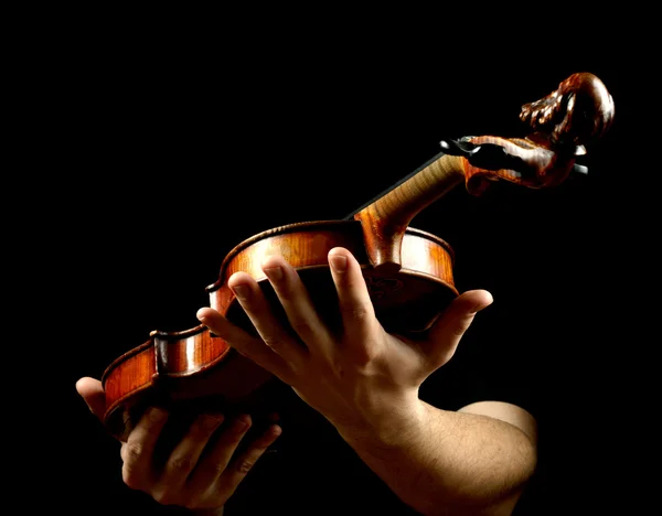 Mãos segurando violino isolado no fundo preto — Fotografia de Stock