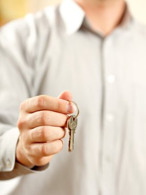 Man holding key. Shallow DOF, focus on key clipart