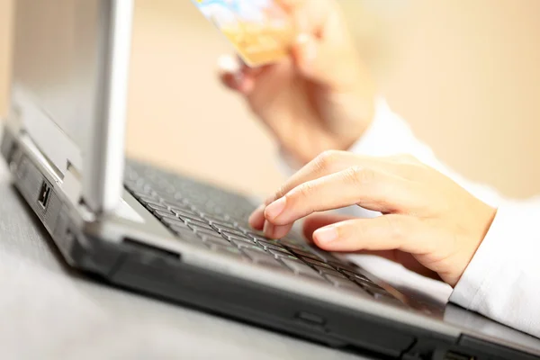 Mãos segurando cartão de crédito e laptop. DOF superficial — Fotografia de Stock