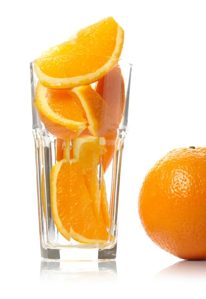 Oranje en segmenten in glas geïsoleerd op witte achtergrond — Stockfoto