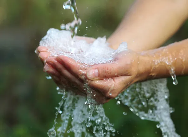 Жіночі руки з водяними бризками — стокове фото