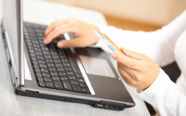 Mãos segurando cartão de crédito e laptop. DOF superficial — Fotografia de Stock