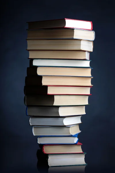 Pilha de livros sobre um fundo preto — Fotografia de Stock