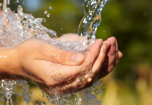 Mãos de mulher com respingo de água — Fotografia de Stock