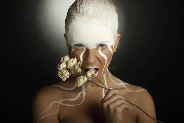 De vrouw met een bloem, met creatieve gezicht-kunst Stockfoto