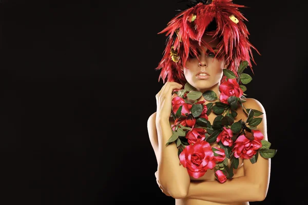 Молодая женщина с красным пером и цветами — стоковое фото