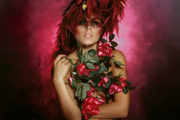 Η νεαρή γυναίκα με ένα κόκκινο φτερό και χρώματα — Φωτογραφία Αρχείου