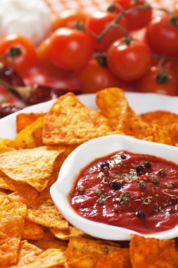 Tortilla chips with hot salsa dip clipart