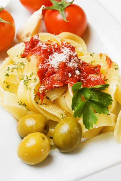 Fettuccine pasta with tomato and olives — Stock Photo, Image